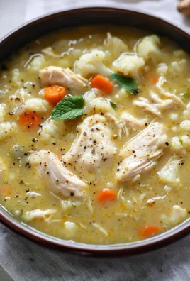 Bowl of anti-inflammatory cauliflower chicken soup with fresh herbs