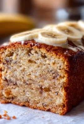 Moist banana bread cake topped with nuts and drizzled with caramel.