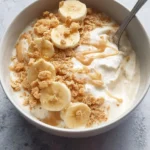 Delicious Banana Pudding Greek Yogurt Bowl topped with slices of banana.