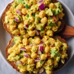 Delicious bowl of best curried chickpea salad topped with fresh herbs.