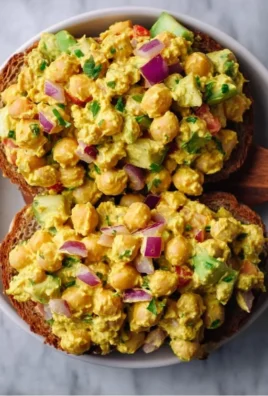 Delicious bowl of best curried chickpea salad topped with fresh herbs.