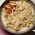 Creamy white sauce pasta dish with herbs and vegetables