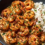 Creamy garlic shrimp dish served in a bowl garnished with herbs.