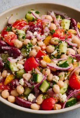 Bowl of Lemony Greek Bean Salad with fresh vegetables and herbs