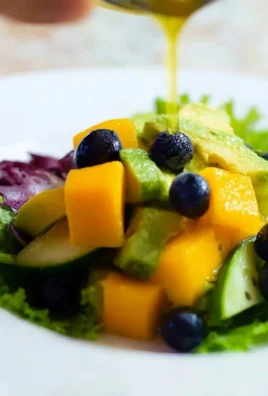 Mango cucumber salad with blueberries and avocado on a plate.