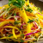 Colorful mango slaw with fresh vegetables in a bowl