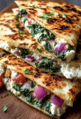 Mediterranean Quesadillas with spinach, feta, mozzarella, and red onion on a plate