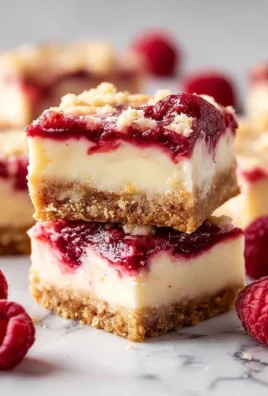 Decadent Raspberry Cheesecake Bars with a creamy layer and fresh raspberry topping