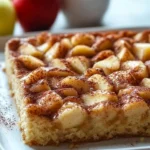 Delicious Apple Cinnamon Sheet Cake served on a wooden table.