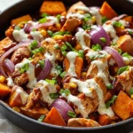 BBQ chicken sweet potato skillet in a cast iron pan with fresh herbs.