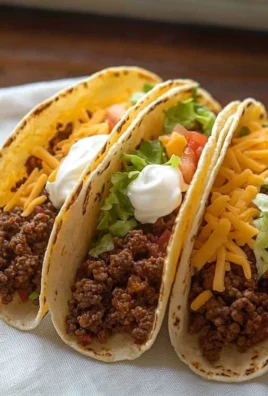 Delicious cheesy and crispy ground beef tacos served on a plate