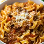 A plate of creamy ground beef pasta garnished with parsley