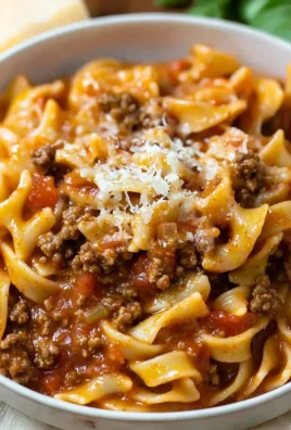 A plate of creamy ground beef pasta garnished with parsley