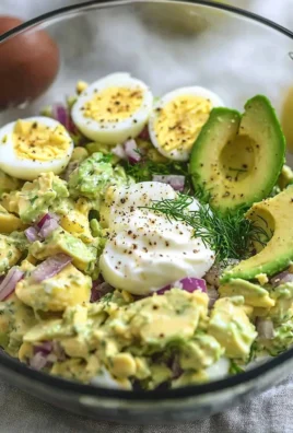 Herby avocado egg salad served in a bowl with fresh herbs and spices.