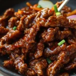 Plate of homemade crispy chilli beef garnished with green onions