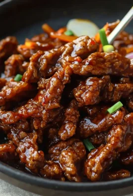 Plate of homemade crispy chilli beef garnished with green onions