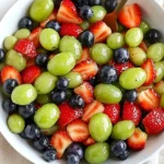 Bowl of colorful honey lime fruit salad with fresh fruits and lime dressing