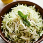 Bowl of colorful Lebanese Cabbage Slaw garnished with fresh herbs.