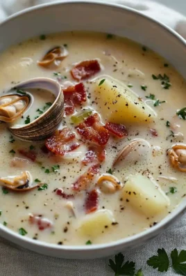 Bowl of New England clam chowder topped with parsley and served with crackers