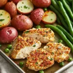 Delicious Parmesan Crusted Chicken served on a sheet pan with vegetables