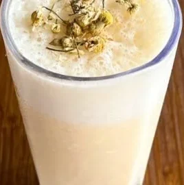 A refreshing Banana Chamomile Tea Smoothie with banana and chamomile flowers.