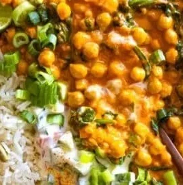 A bowl of flavorful chickpea curry served with rice and herbs