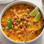 Chickpea Curry Soup in a bowl, garnished with fresh herbs and spices.