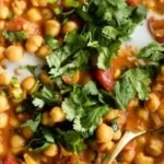 Bowl of Coconut Chickpea Curry topped with fresh herbs