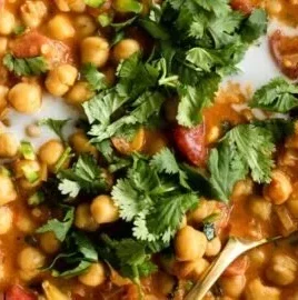 Bowl of Coconut Chickpea Curry topped with fresh herbs