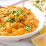 Delicious coconut curry chickpeas dish garnished with fresh herbs