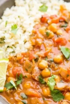 Bowl of creamy vegan Coconut Chickpea Curry topped with fresh herbs.