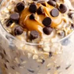 Bowl of dreamy peanut butter chocolate chip overnight oats with chocolate chips on top