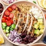 Healthy Greek Chicken Quinoa Bowl with fresh vegetables and feta cheese
