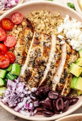 Healthy Greek Chicken Quinoa Bowl with fresh vegetables and feta cheese