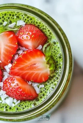 A vibrant bowl of Strawberry Matcha Overnight oats topped with fresh strawberries.