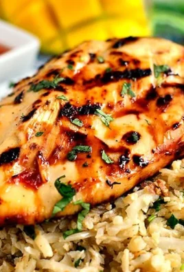 Sweet chili coconut-lime grilled chicken on a platter garnished with lime wedges.