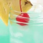 Delicious Blue Hawaiian Mocktail in a glass with tropical garnishes
