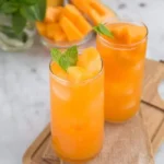 Glass of refreshing cantaloupe water served with mint leaves