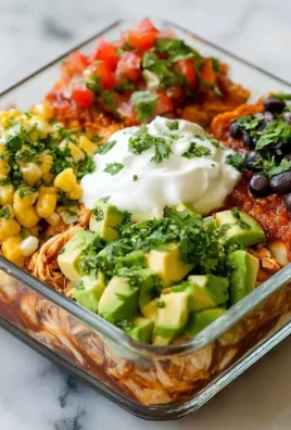 A delicious bowl of chicken enchiladas garnished with fresh ingredients.
