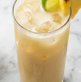 Coconut Lime Pineapple Mocktail served in a glass with tropical fruit garnishes.