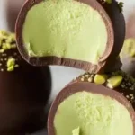 Delicious creamy pistachio ganache truffles on a wooden surface.