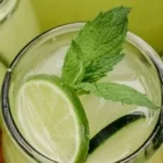 Refreshing Cucumber Lime Cooler beverage served in a glass with mint garnish