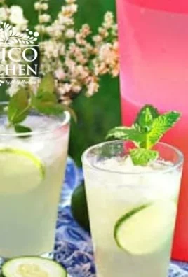 A refreshing glass of cucumber lime water garnished with fresh cucumber slices and lime wedges