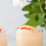 Frozen Paloma cocktail served with a lime wedge and salt rim.
