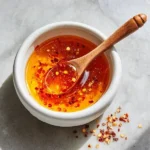 Bottle of Garlic Hot Honey showcasing its vibrant color and label