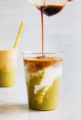 Iced Pistachio Latte in a glass with a straw and pistachio garnish