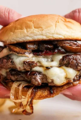 Delicious Mushroom Swiss Burger served with fresh toppings and side fries.