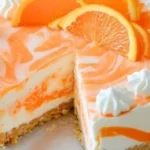 No-Bake Orange Creamsicle Cheesecake topped with whipped cream and orange slices.