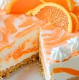 No-Bake Orange Creamsicle Cheesecake topped with whipped cream and orange slices.