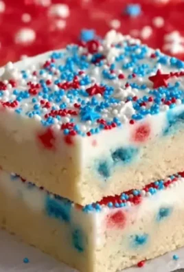 Delicious patriotic sugar cookie bars topped with red, white, and blue sprinkles.